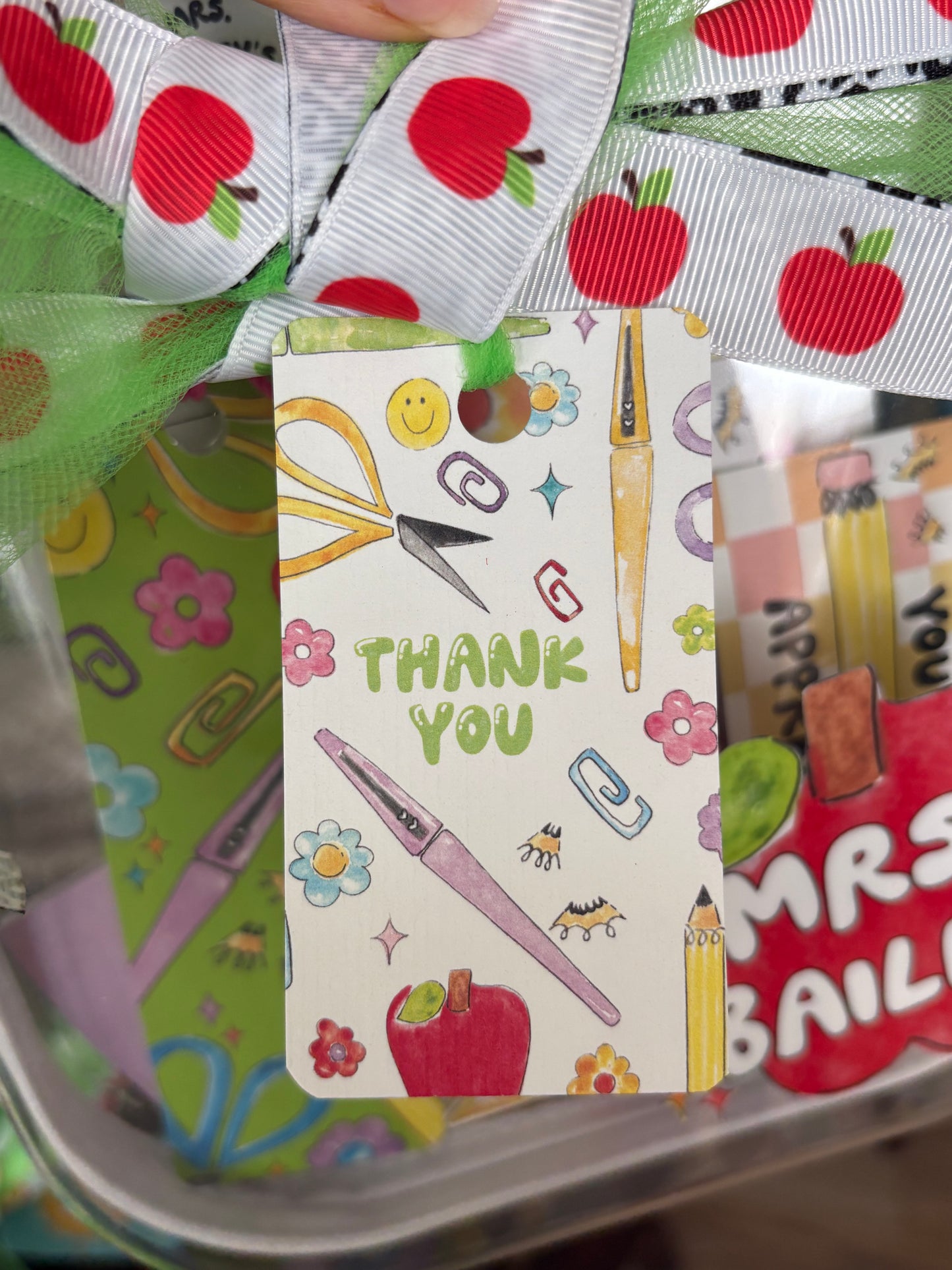 Colorful stationery-themed gift tag with ribbons and stationery items.