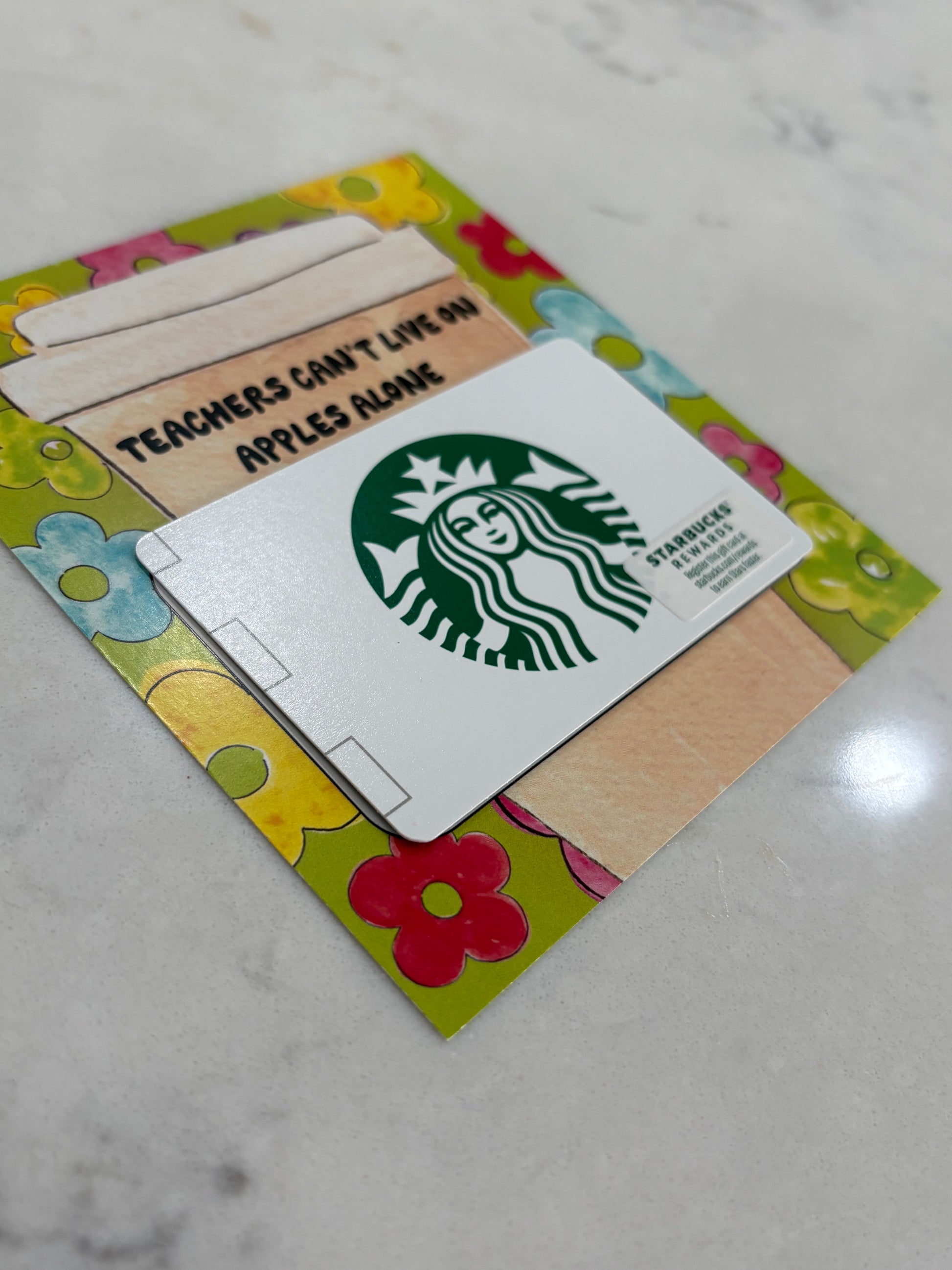 Starbucks gift card on a colorful card with flowers on a marble surface