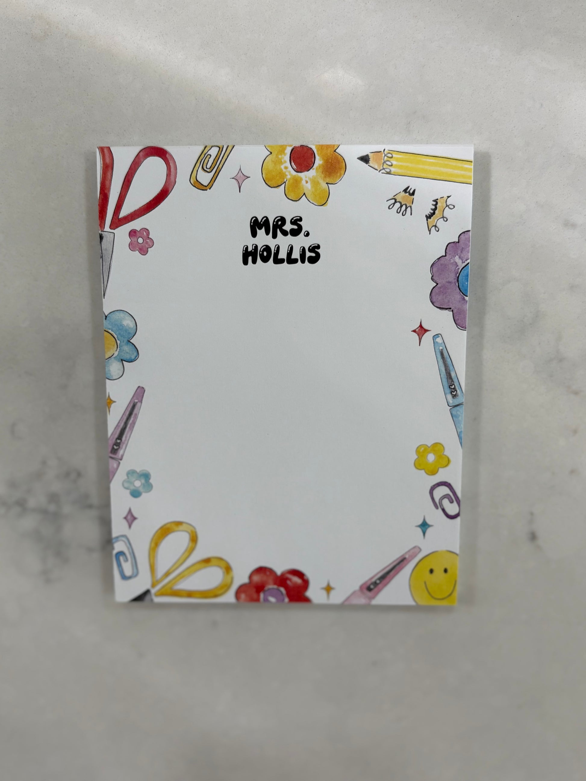 Notebook with colorful illustrations and 'Mrs. Hollis' text on a gray background