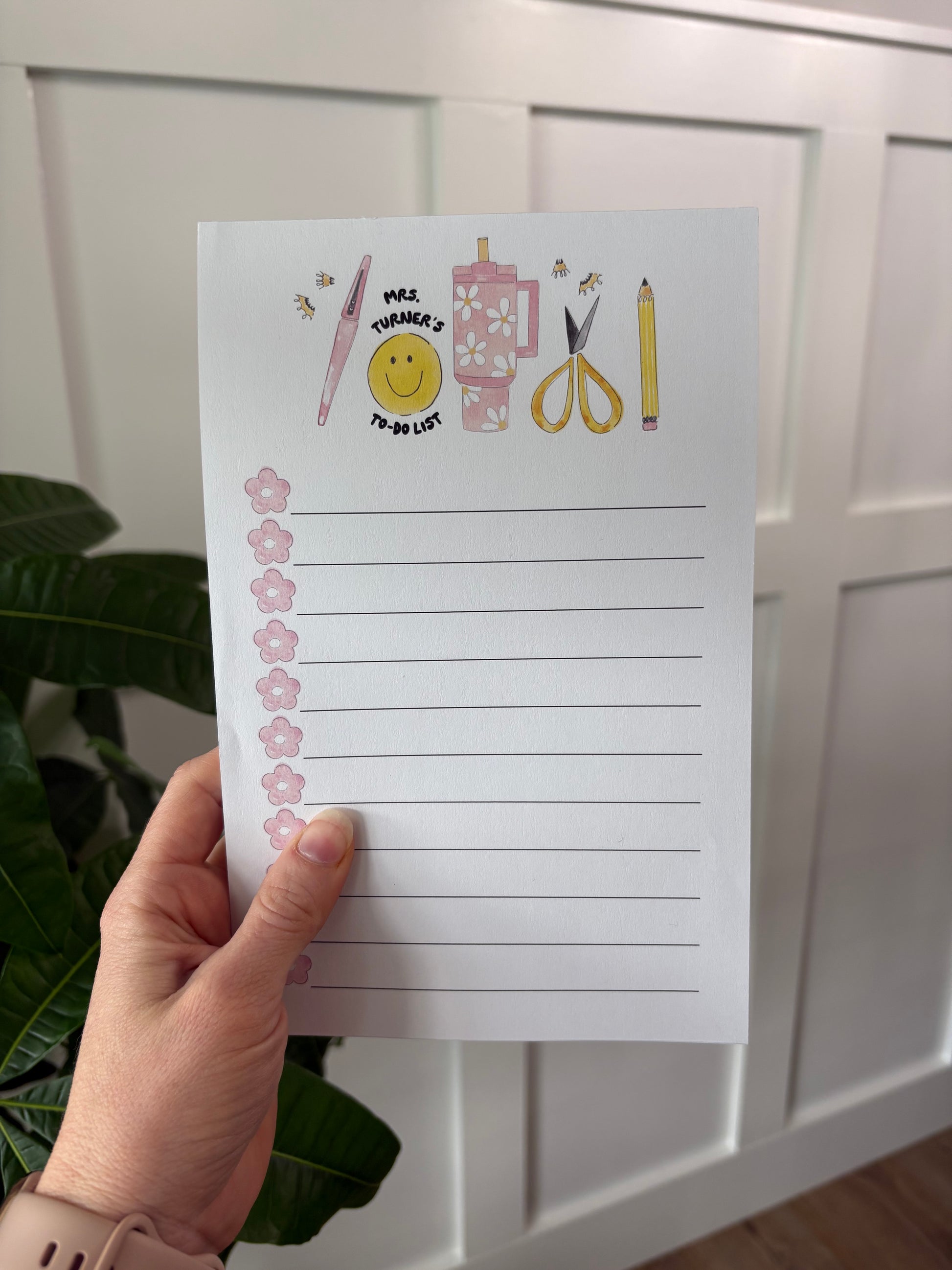 Hand holding a notepad with lines on a white surface.