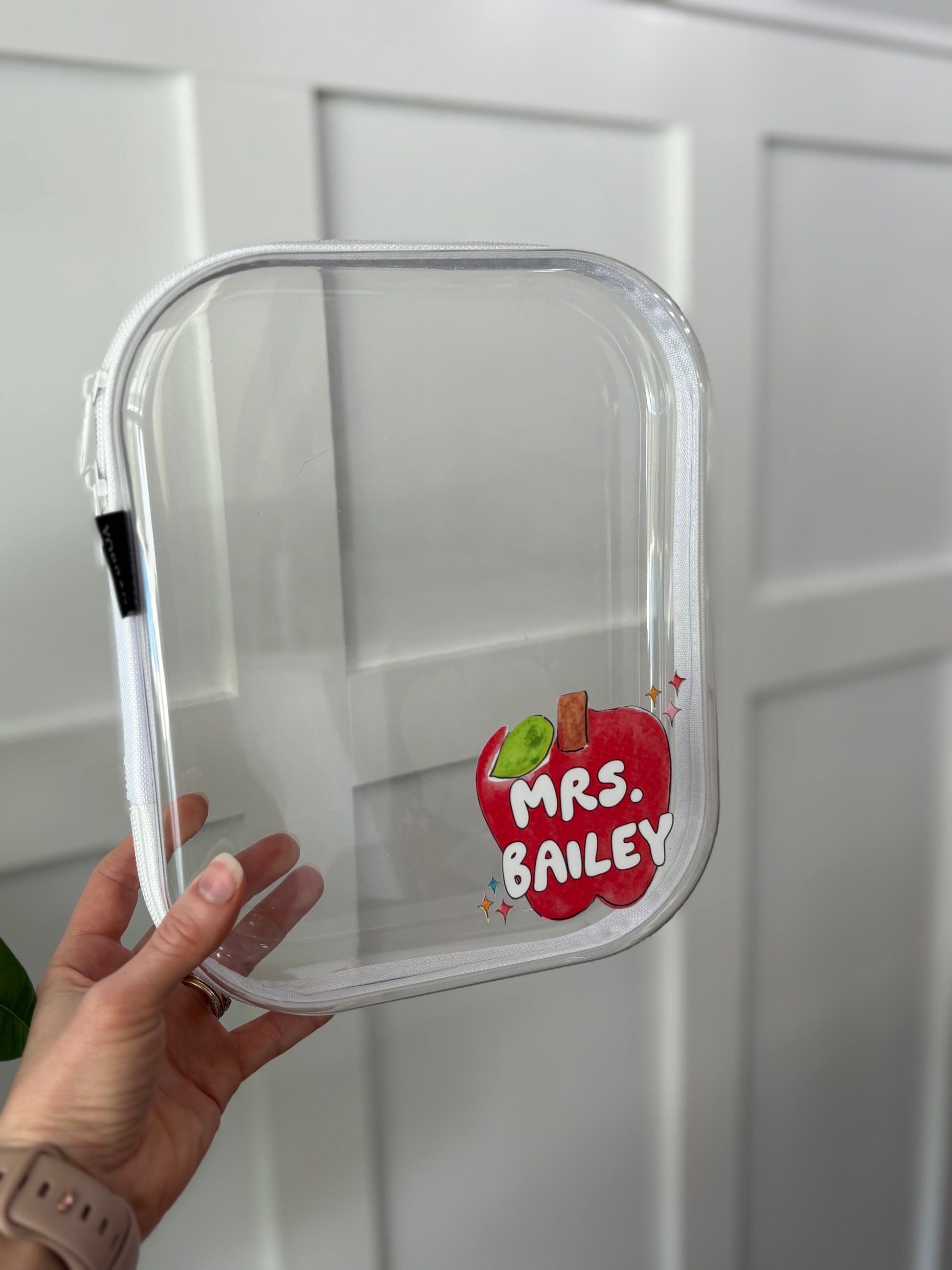 Clear container with 'Mrs. Bailey' label held by a hand against a white background