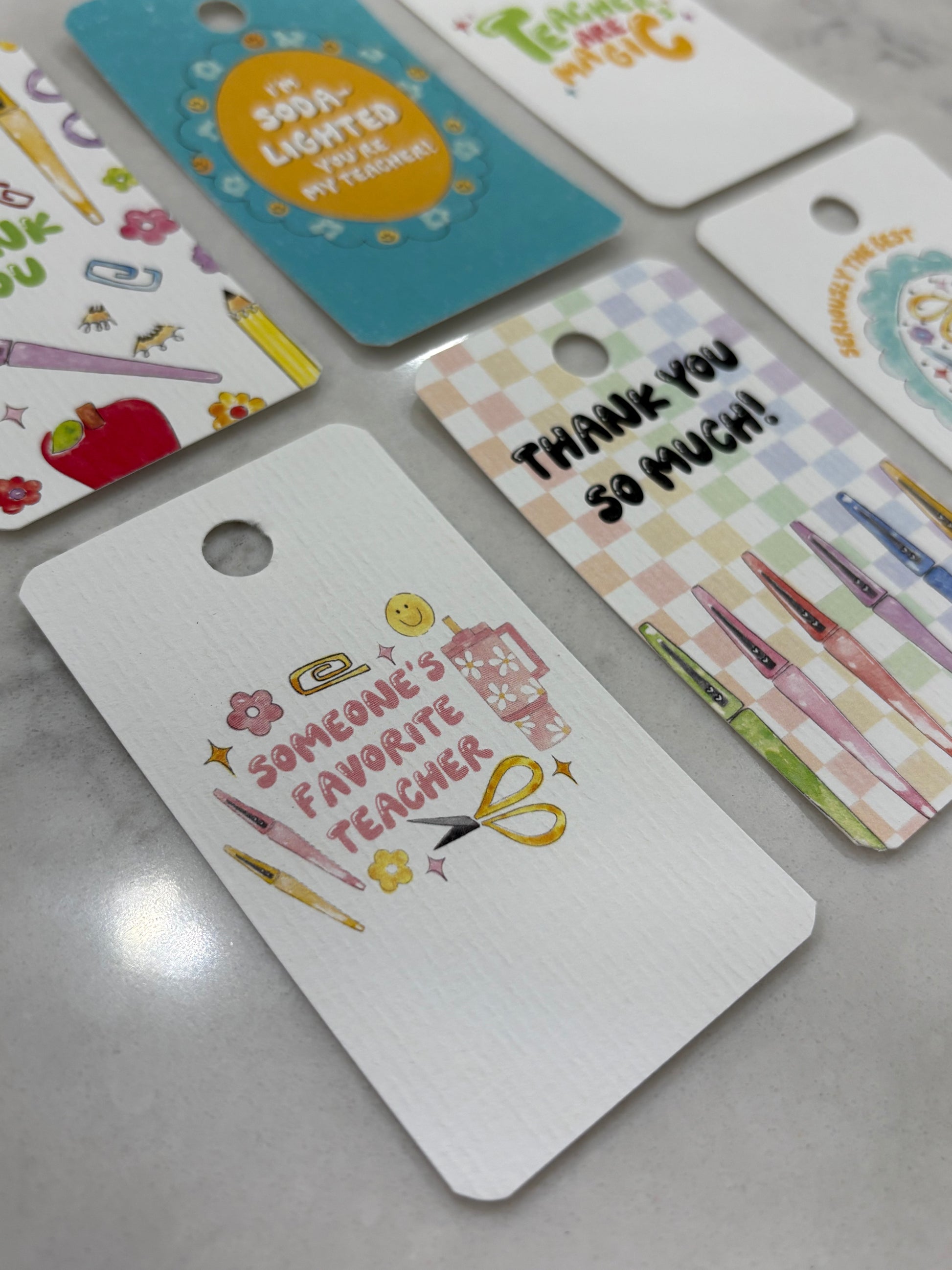 Collection of colorful gift tags with various designs on a gray surface