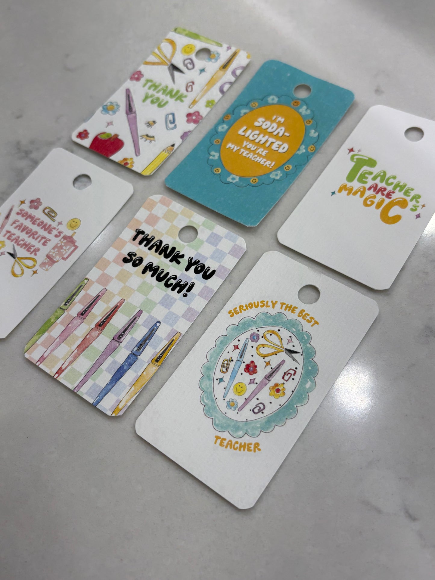Set of colorful gift tags with various designs on a gray surface