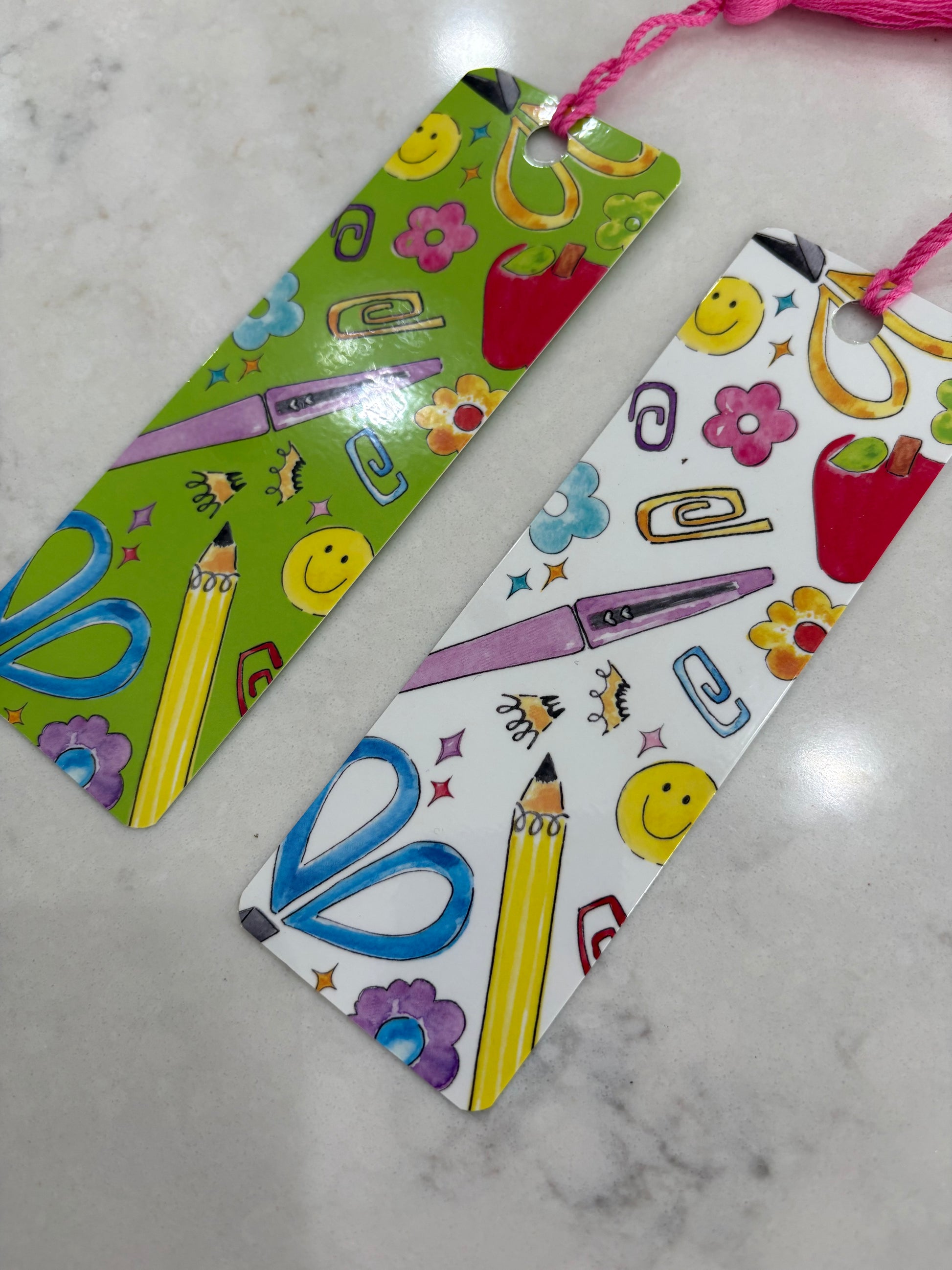 Colorful bookmarks with stationery-themed designs on a marble surface