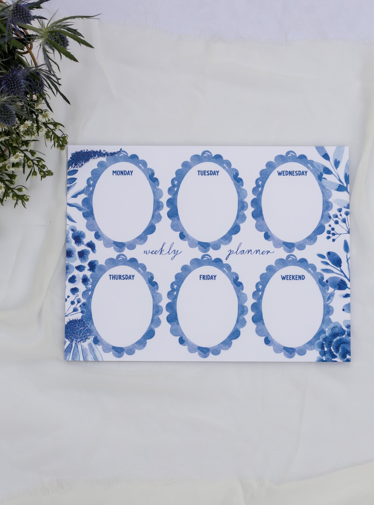 Weekly planner with blue decorative elements on a white surface
