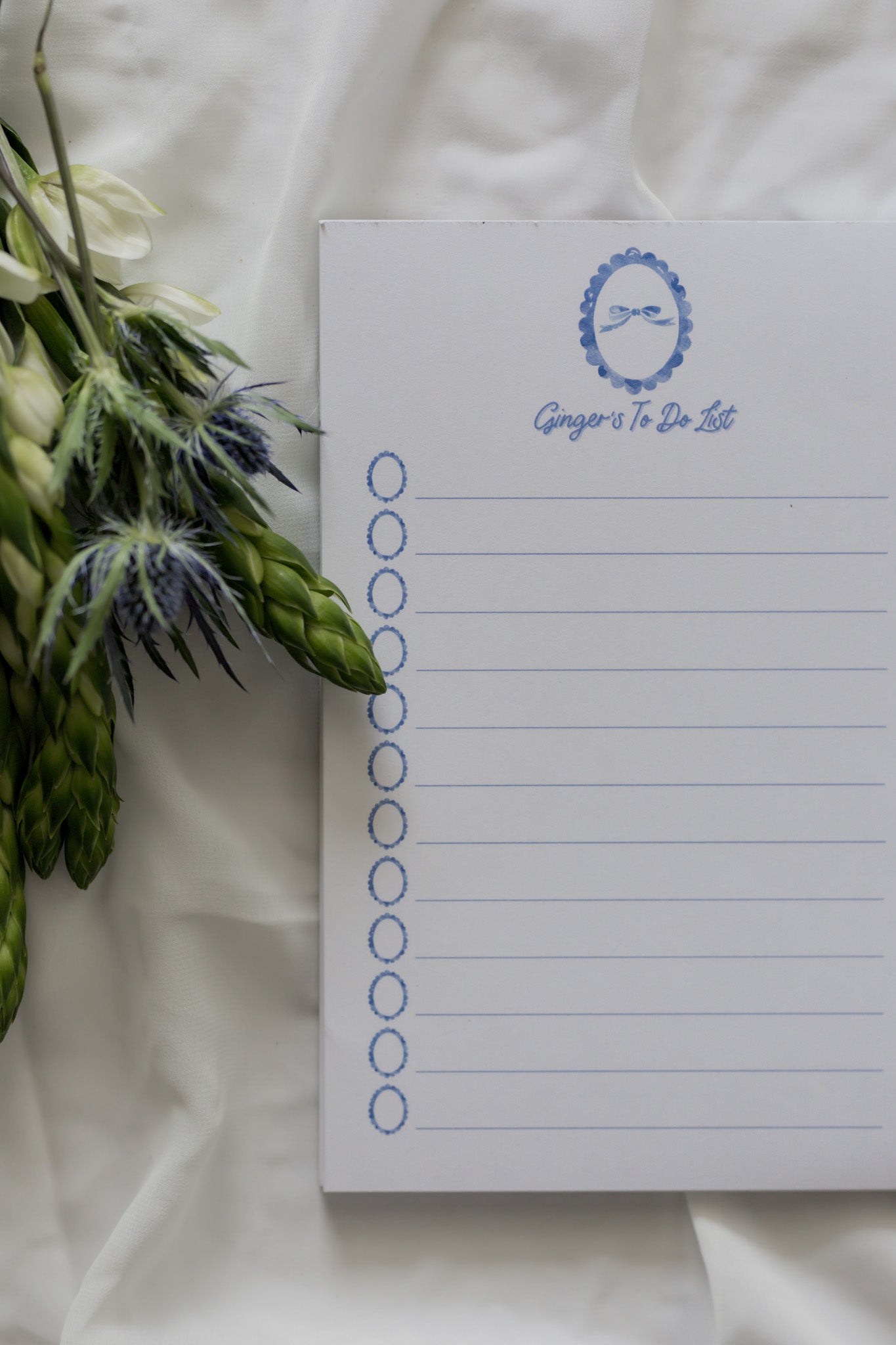 Bow Notepad with lines on a white background with a flower arrangement 