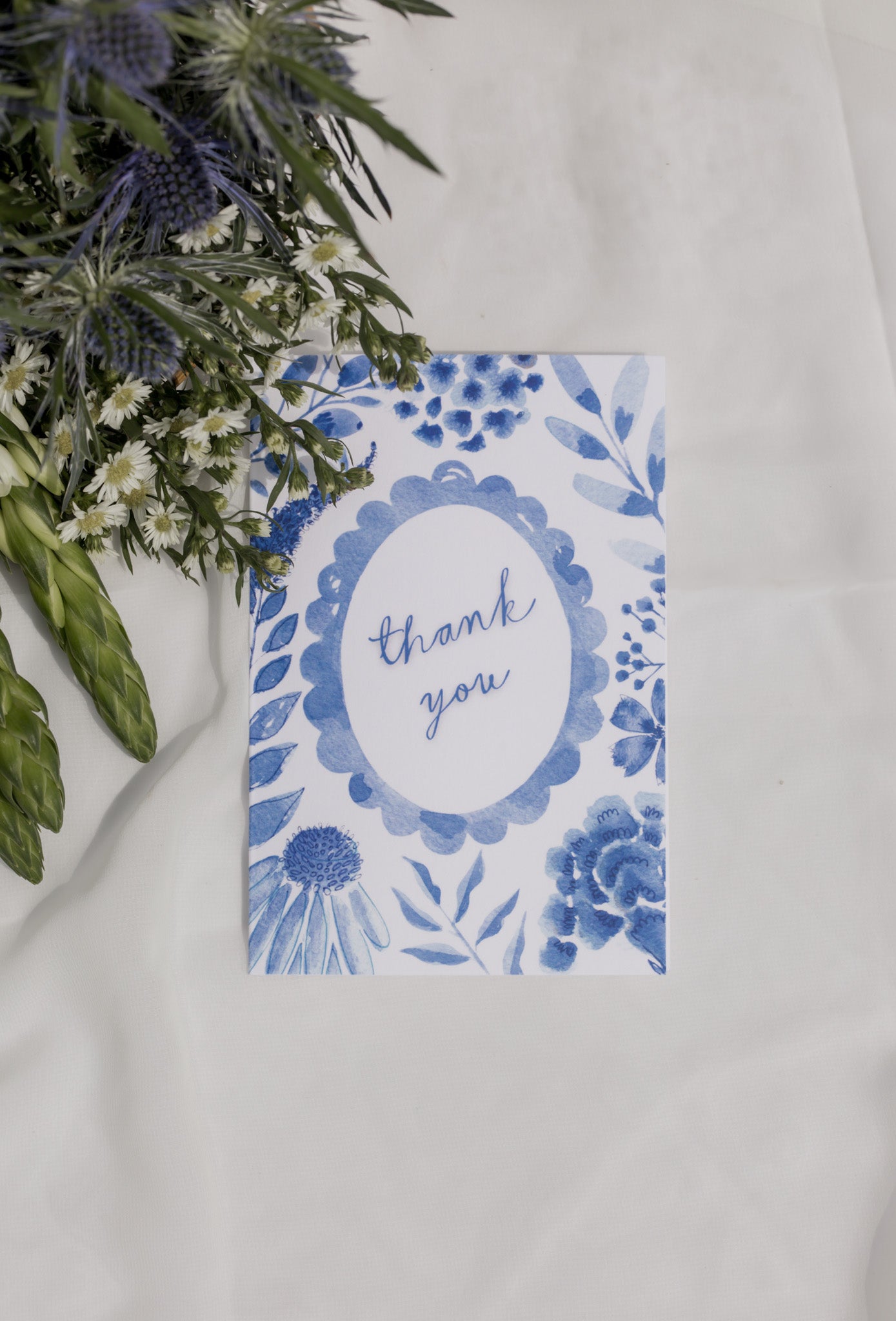 Blue floral card with 'thank you' text on a white background