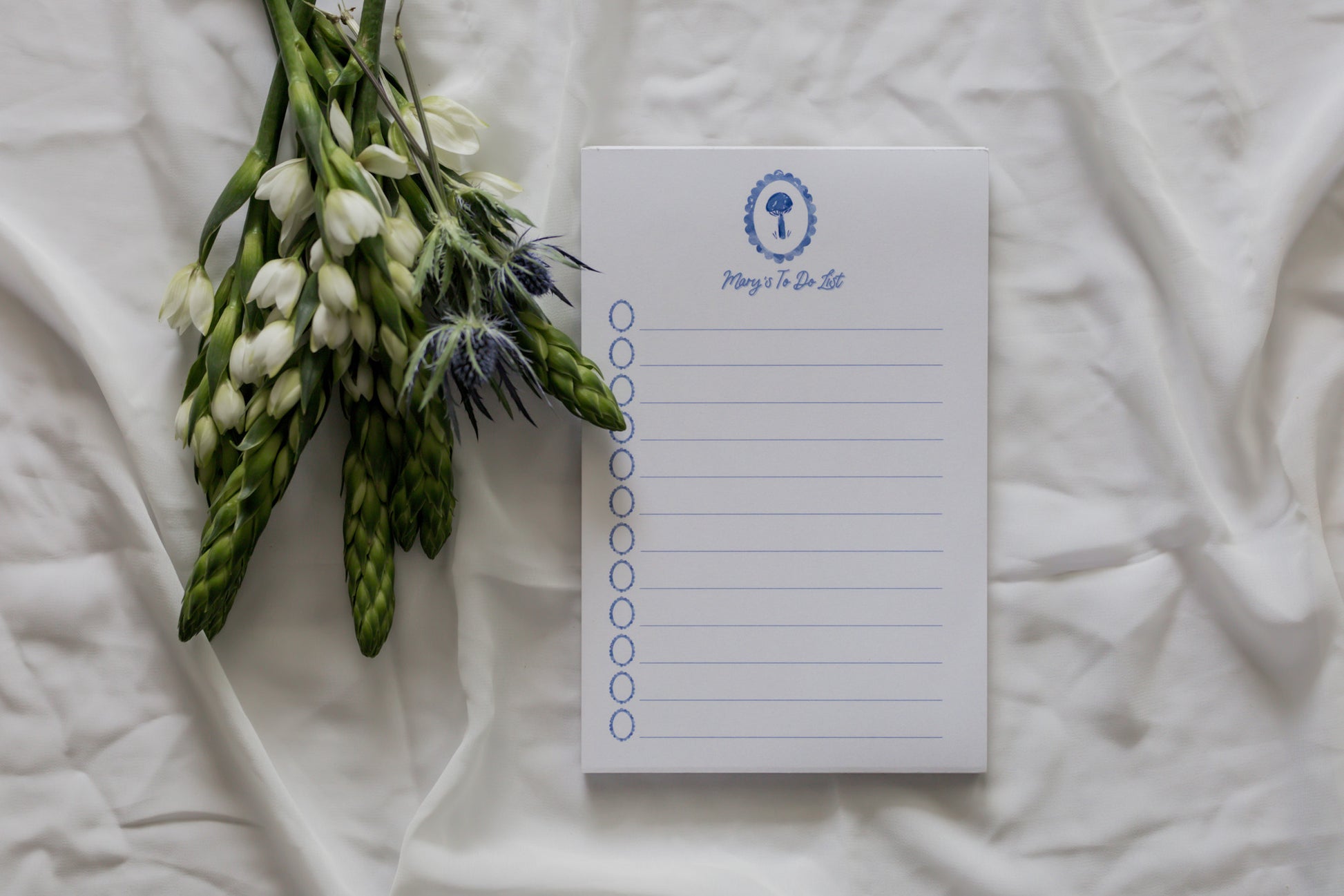 Notepad with a floral arrangement on a white fabric background