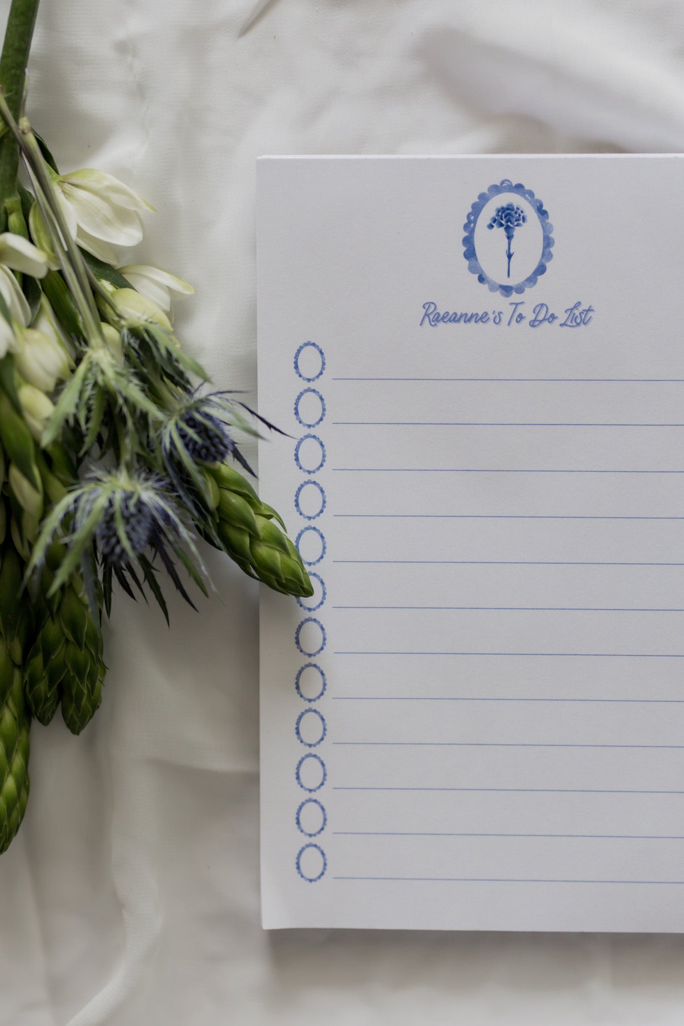 Notepad with a carnation design on a white fabric background