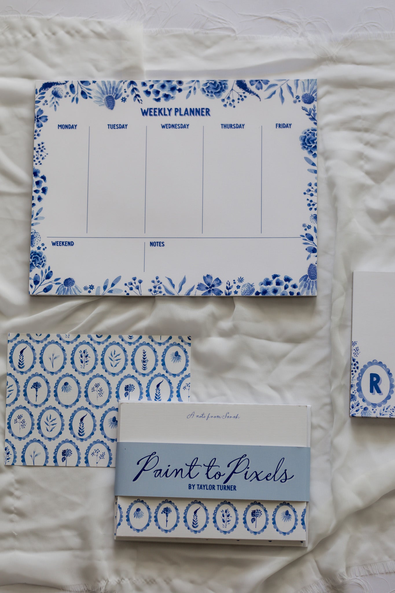 Set of blue and white patterned planners on a white surface